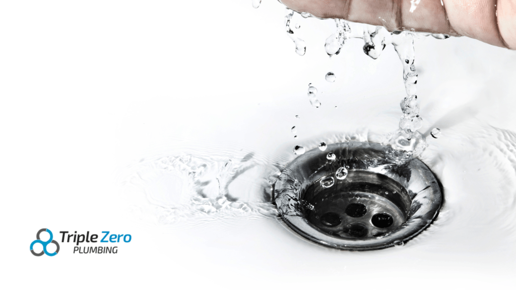 Person pouring chemical drain cleaner into a clogged drain in a white sink, illustrating effective methods for clearing blocked drains